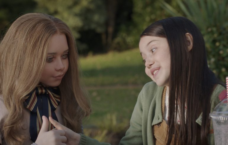 Violet McGraw is seen here with M3gan in a scene from Blumhouse M3gan