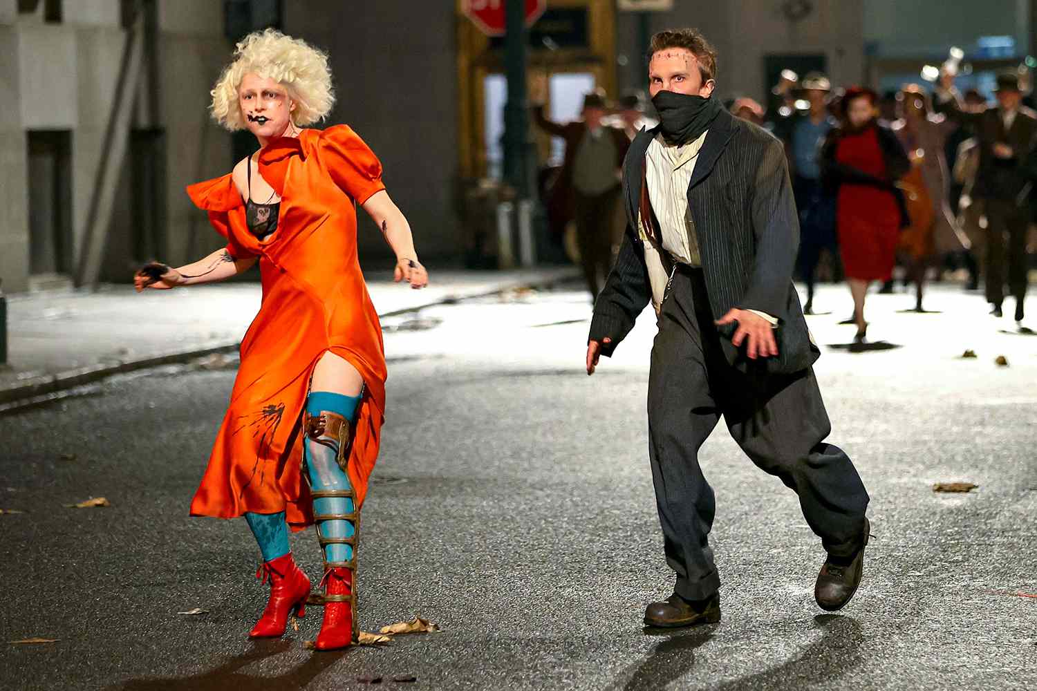 Jessie Buckley as the Bride and Christian Bale as Frankenstein run through the streets in Warner Bros.’ The Bride, directed by Maggie Gyllenhaal.