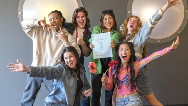 Daniella Monet poses with the new Hollywood Arts cast holding the script for the Victorious spinoff confirmed by Netflix.