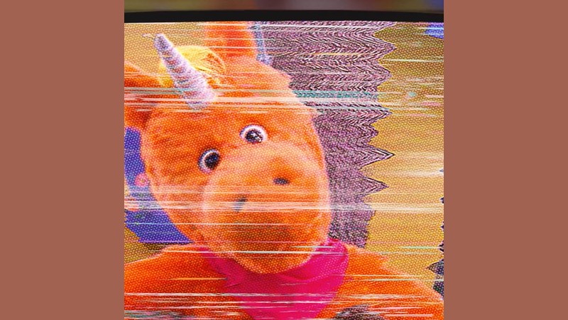 Buddy the orange unicorn mascot in the official Sing-Along Version poster art