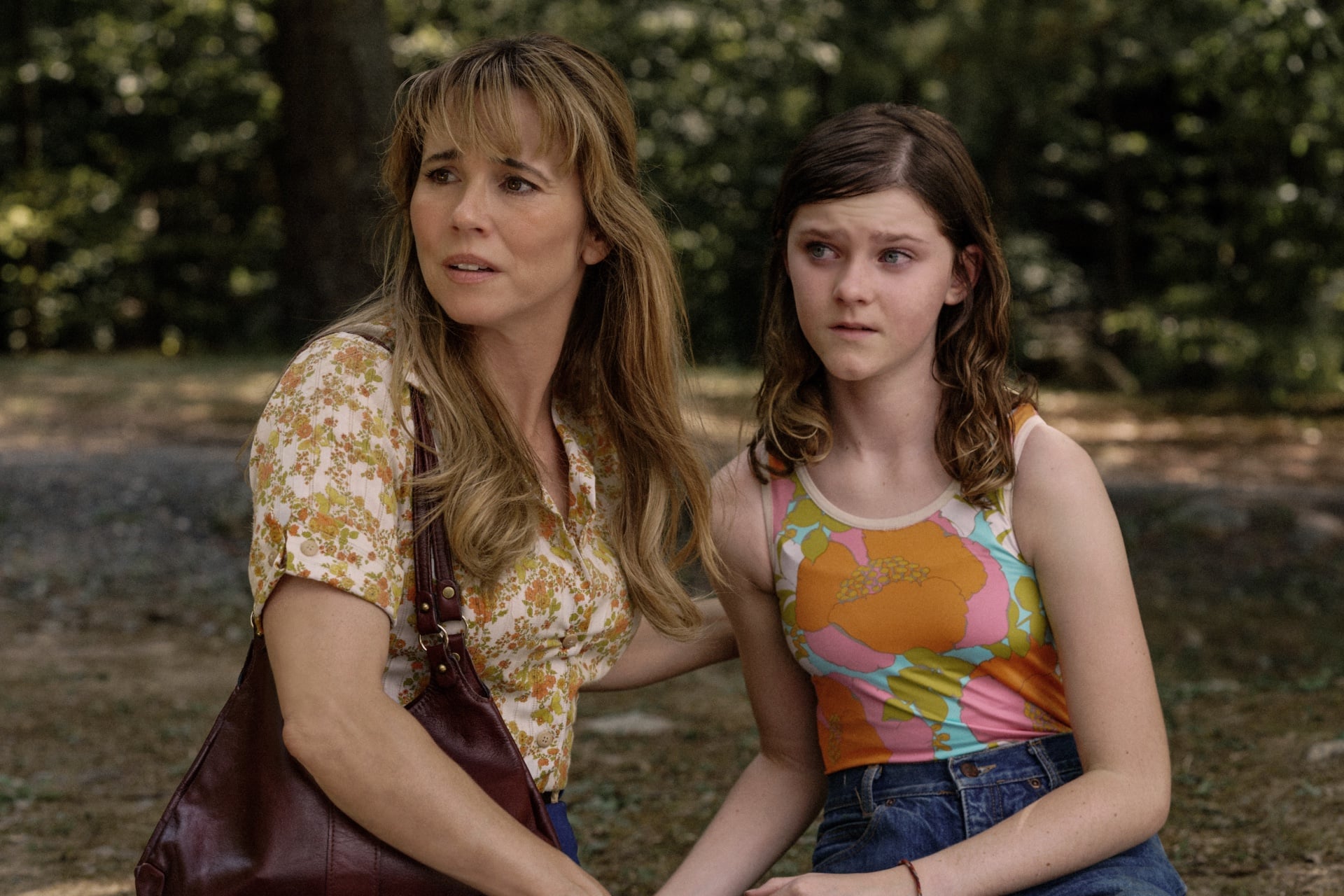 Linda Cardellini as Pam Voorhees with a young girl in the woods in a publicity still from Peacock's Crystal Lake