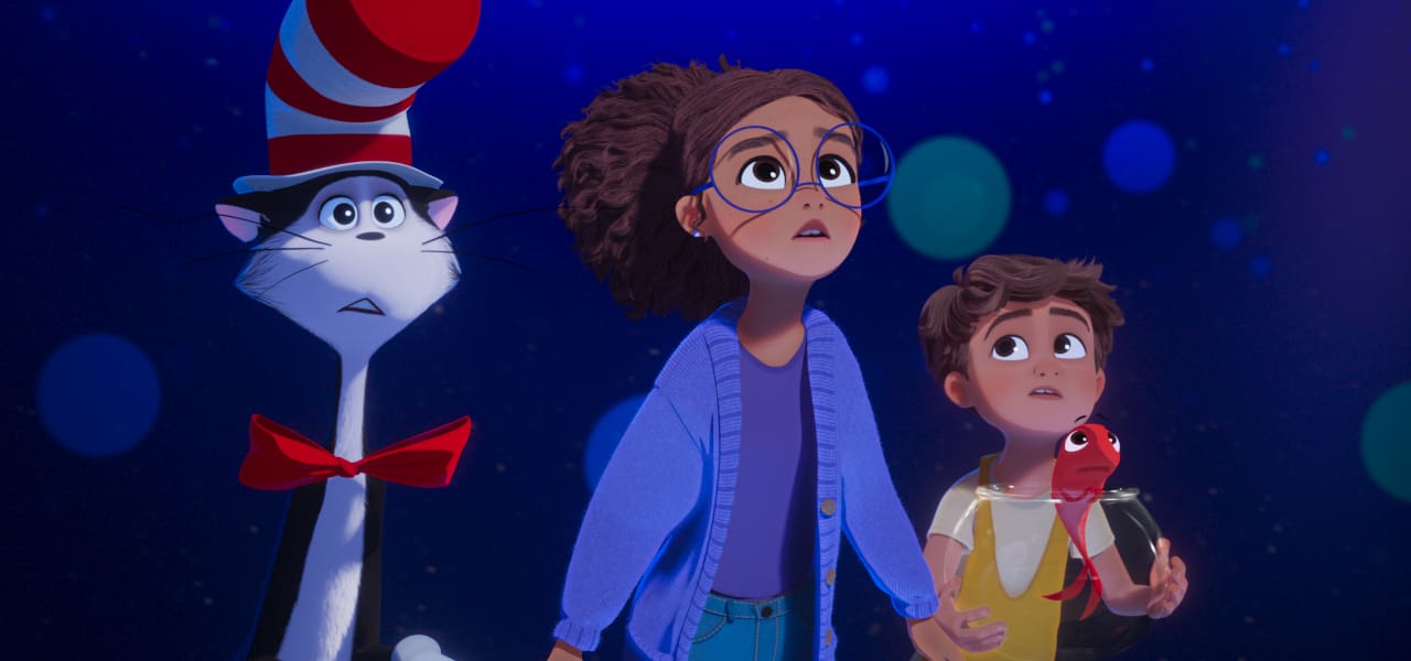 The Cat in the Hat stands beside siblings Gabby and Sebastian, who holds a fishbowl, against a starry blue background in Warner Bros. Pictures Animation’s The Cat in the Hat