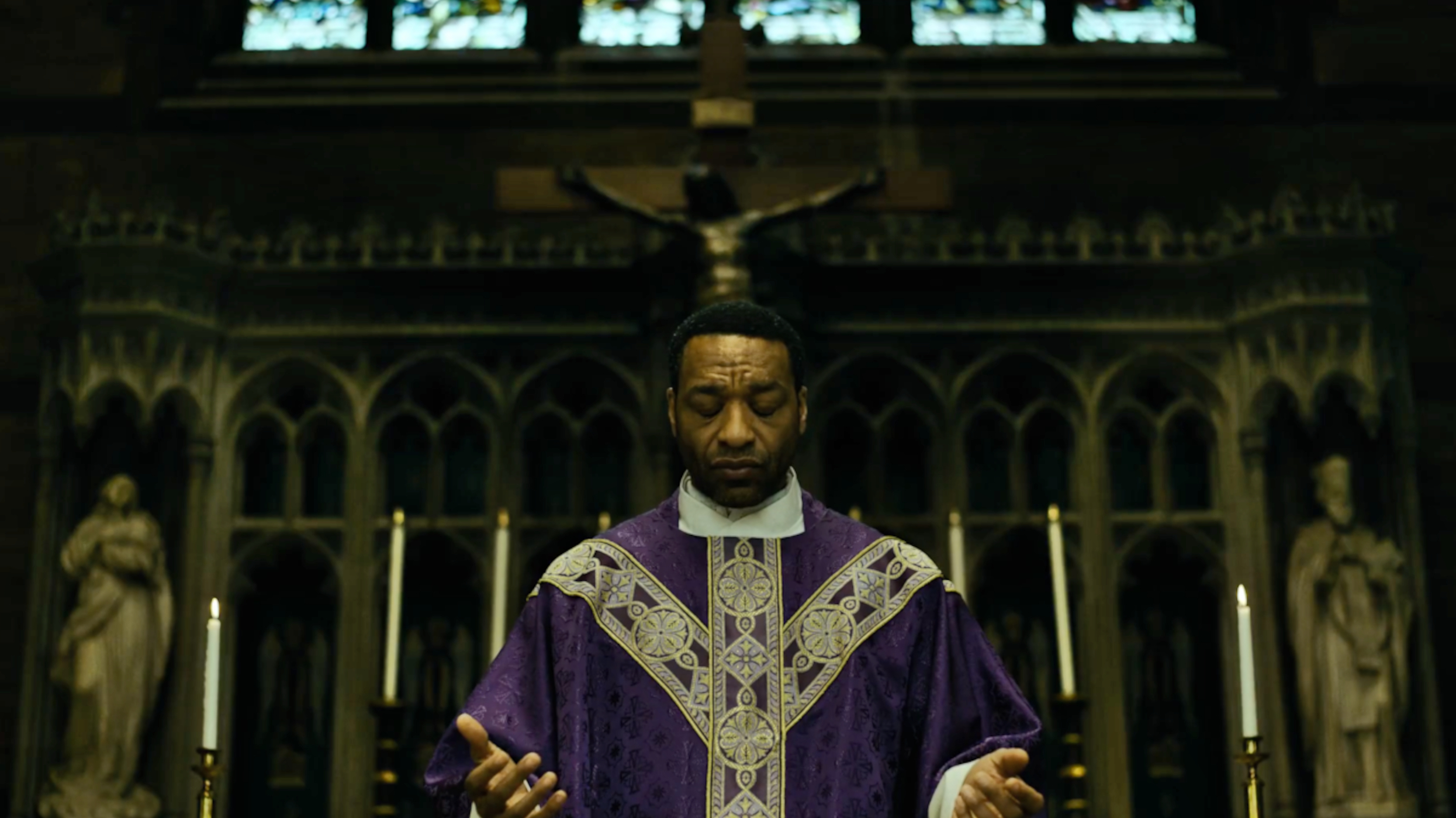 Chiwetel Ejiofor as a priest in a church in Mike Flanagan's The Exorcist: Martyrs