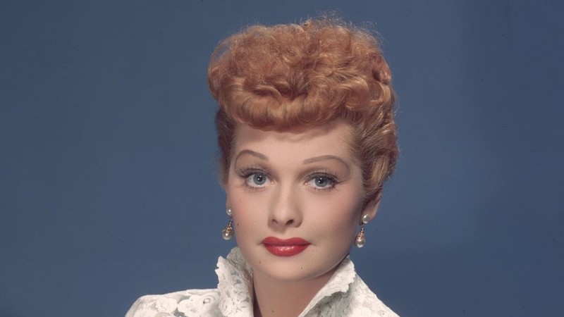 Lucille Ball in a 1950s publicity portrait, wearing a white lace jacket over a black dress