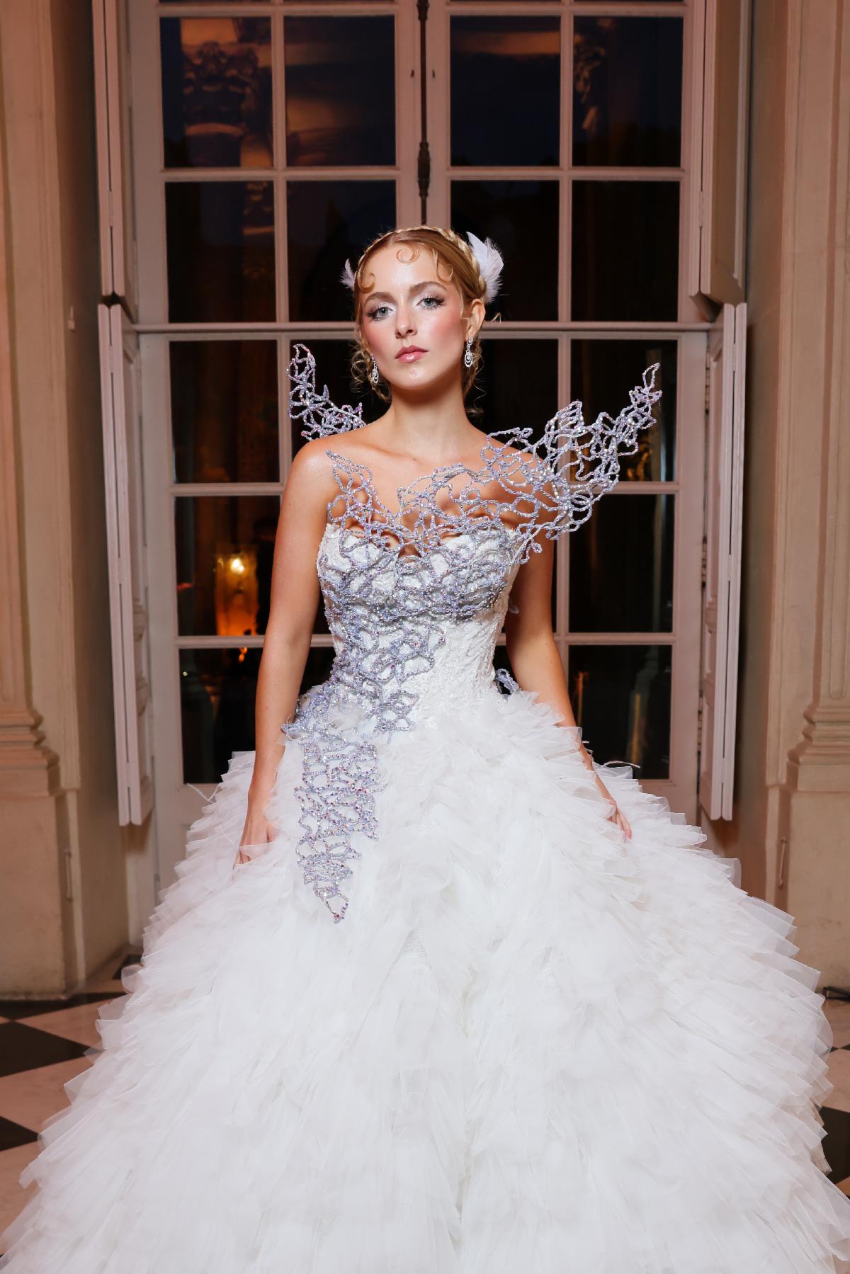 Mckenna Grace in a white Monique Lhuillier gown at the Hunger Games Paris fashion event